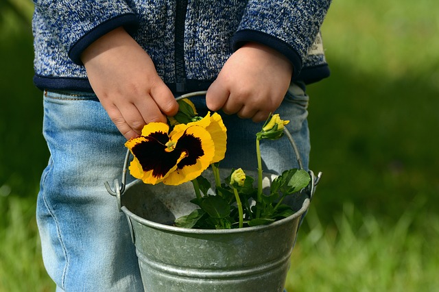 Ett barn med en blomma i handen.