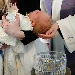 En bild på ett barn som blir döpt.