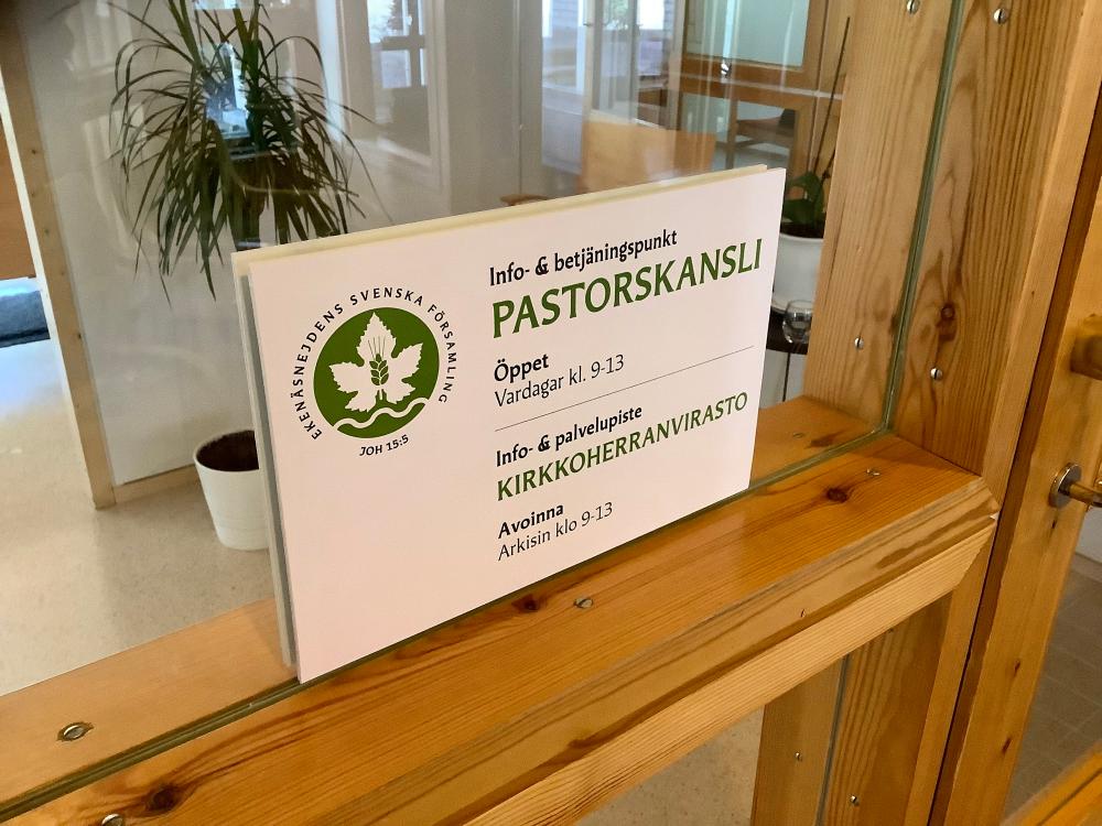 Bild av skylt med öppettiderna vid pastorskansliet i Ekenäs.